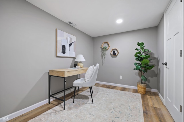 office area with visible vents, baseboards, and wood finished floors