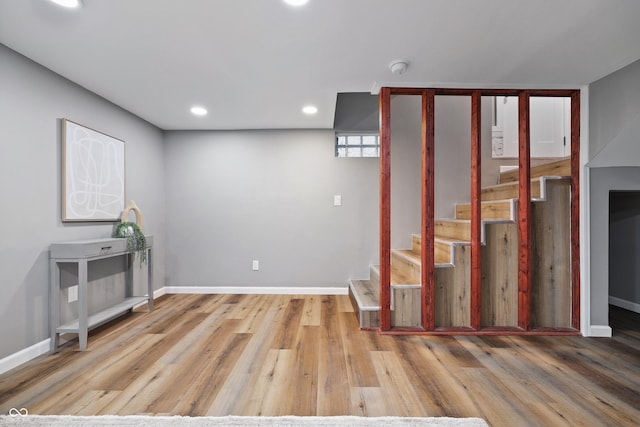 basement with stairs, baseboards, and wood finished floors