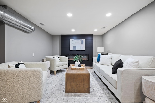 living area featuring recessed lighting, visible vents, and a large fireplace