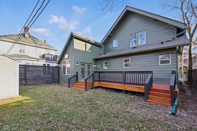 rear view of house featuring an outbuilding, a fenced backyard, a yard, a shingled roof, and a wooden deck