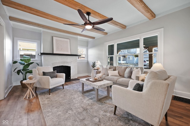 living area with a brick fireplace, wood finished floors, and a wealth of natural light