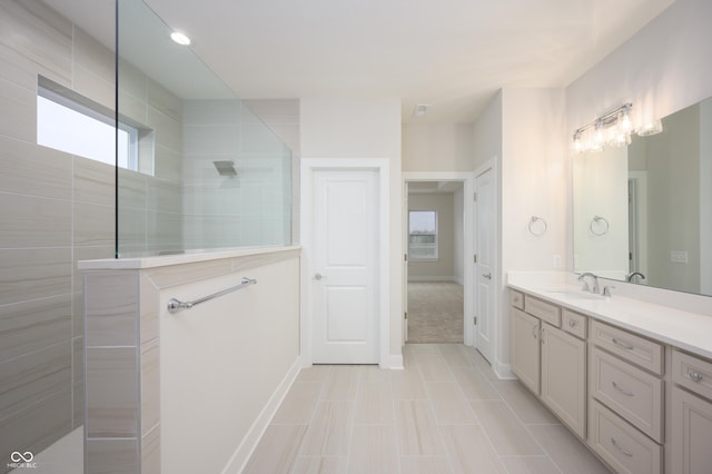 bathroom with a healthy amount of sunlight, vanity, and walk in shower