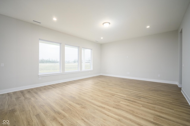 empty room featuring recessed lighting, visible vents, light wood-style flooring, and baseboards