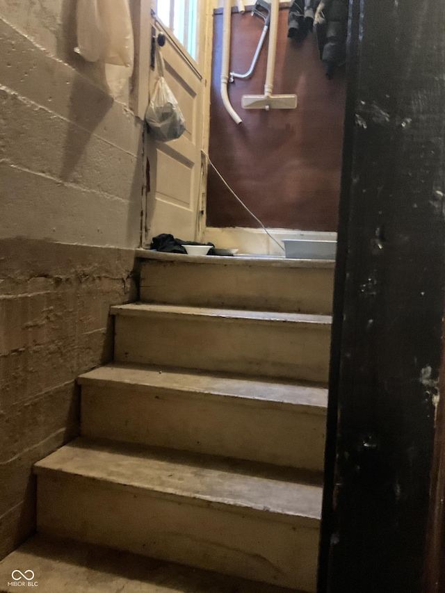 stairs featuring concrete block wall