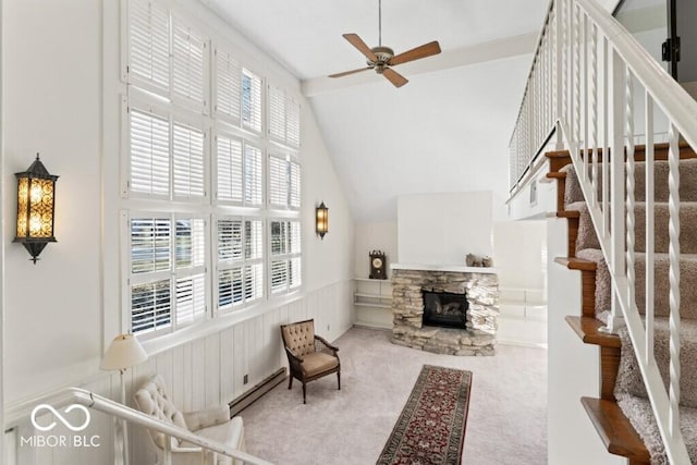 2447 N E Raintree Dr, New Castle, IN 47362 - carpeted living room with ceiling fan, stairs, a wainscoted wall, a fireplace, and vaulted ceiling