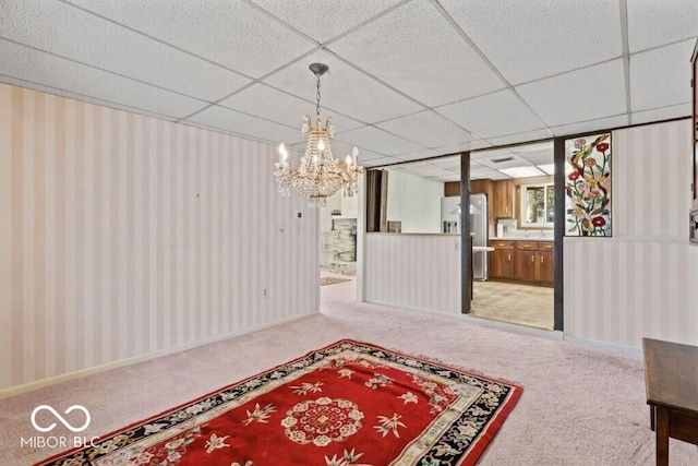 2447 N E Raintree Dr, New Castle, IN 47362 - dining room with light carpet, a chandelier, a paneled ceiling, and wallpapered walls