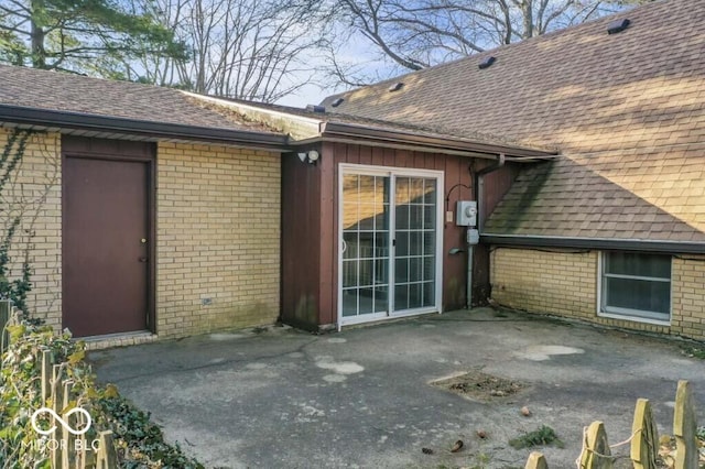 2447 N E Raintree Dr, New Castle, IN 47362 - view of exterior entry with roof with shingles, a patio, and brick siding