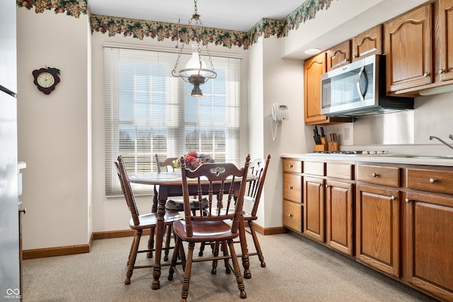 dining area with light colored carpet and baseboards