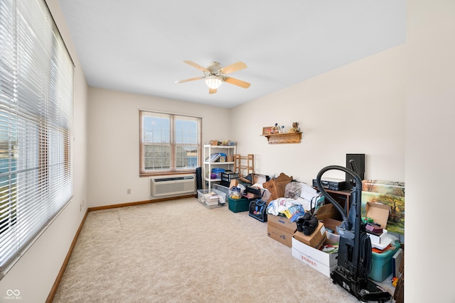 interior space featuring baseboards, carpet floors, an AC wall unit, and a ceiling fan