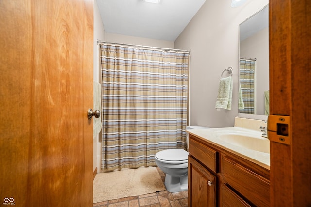 full bathroom featuring shower / bath combination with curtain, stone finish flooring, toilet, and vanity