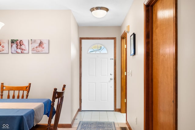 foyer featuring light tile patterned floors and baseboards