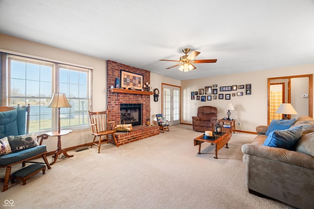 living room featuring a fireplace, carpet, baseboards, and ceiling fan