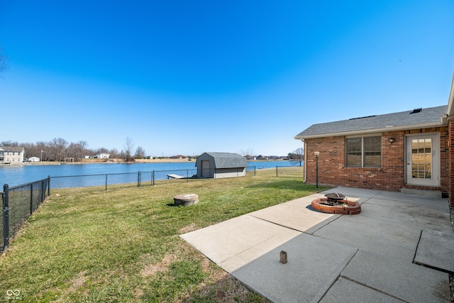 view of yard featuring an outbuilding, a shed, an outdoor fire pit, a fenced backyard, and a patio area