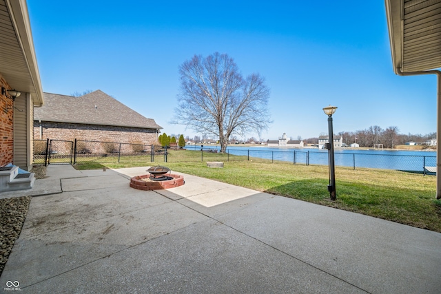 view of patio / terrace with an outdoor fire pit, a fenced backyard, and a water view