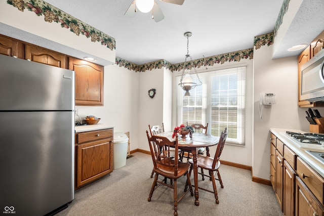 dining area with light colored carpet, baseboards, and ceiling fan