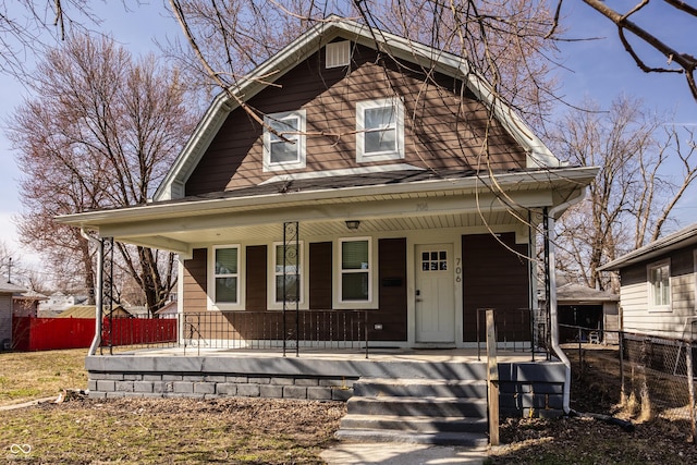 dutch colonial with a porch and fence