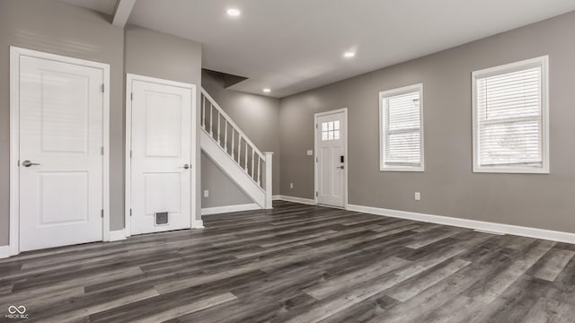 foyer entrance featuring dark wood finished floors, recessed lighting, stairs, and baseboards