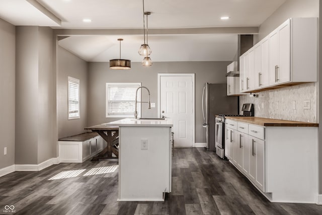 kitchen with an island with sink, a sink, tasteful backsplash, white cabinetry, and gas range