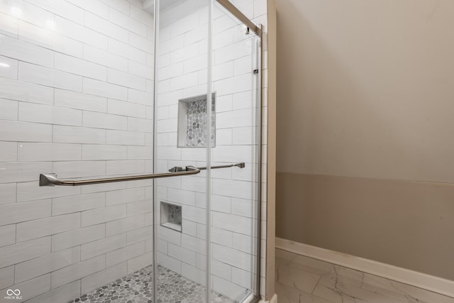 bathroom with baseboards, marble finish floor, and a shower stall