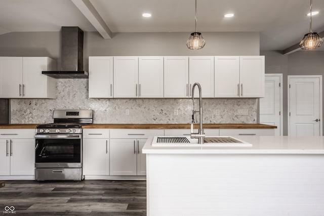 kitchen featuring backsplash, pendant lighting, gas stove, wall chimney exhaust hood, and a sink