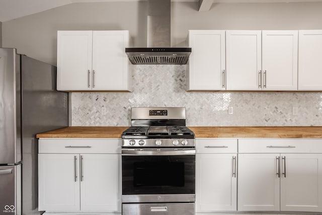 kitchen with wall chimney exhaust hood, tasteful backsplash, wooden counters, and stainless steel appliances