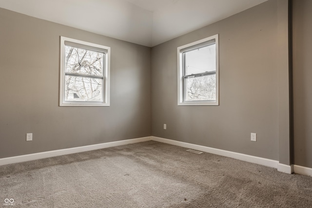 carpeted empty room with visible vents and baseboards