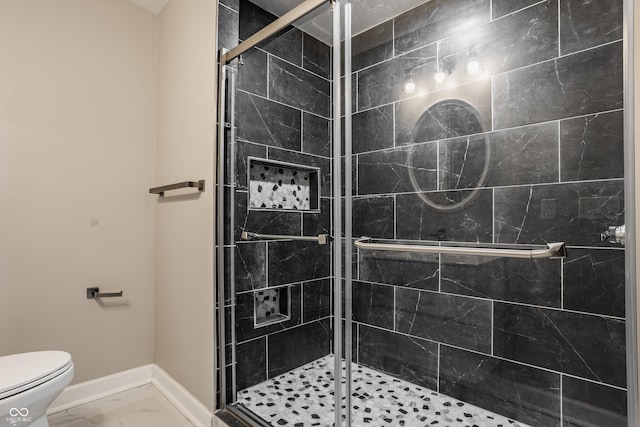 full bathroom featuring marble finish floor, toilet, a shower stall, and baseboards