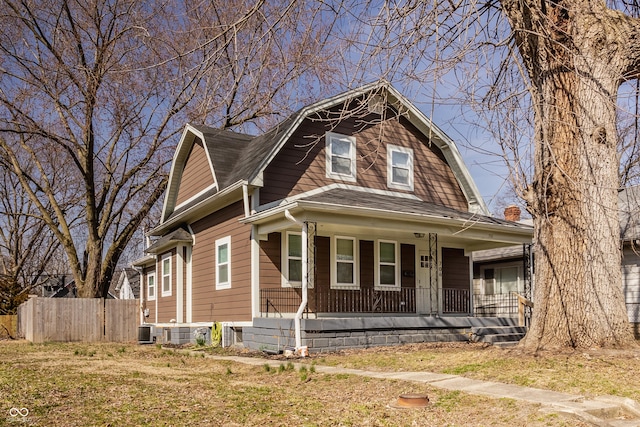 dutch colonial featuring fence, roof with shingles, a porch, a gambrel roof, and central AC