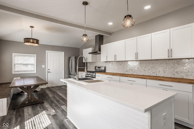 kitchen with lofted ceiling with beams, white cabinets, wall chimney exhaust hood, and appliances with stainless steel finishes