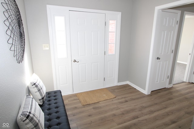 foyer entrance with wood finished floors and baseboards