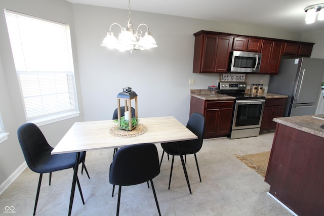 kitchen with baseboards, an inviting chandelier, stainless steel appliances, hanging light fixtures, and dark brown cabinets