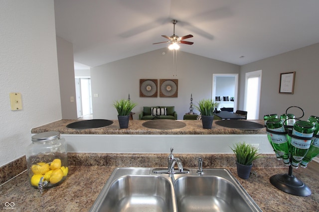 kitchen with open floor plan, lofted ceiling, ceiling fan, and a sink