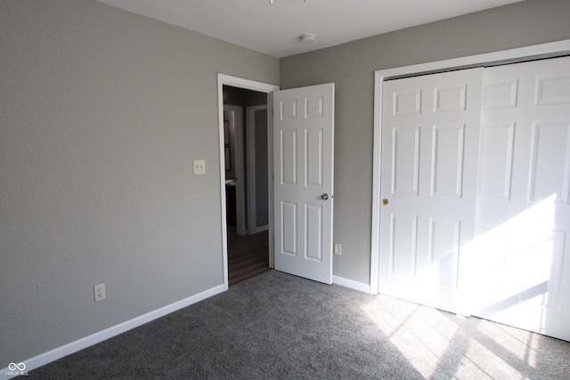 unfurnished bedroom with a closet, baseboards, and carpet flooring