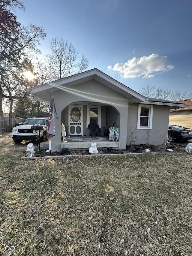 bungalow-style home featuring a front lawn and a porch