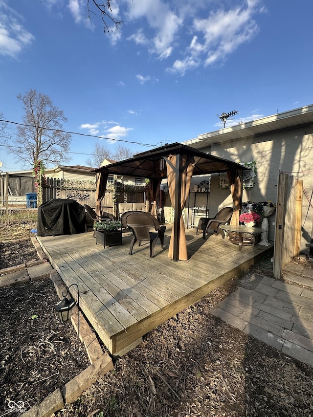 wooden terrace with a gazebo, an outdoor hangout area, fence, and grilling area