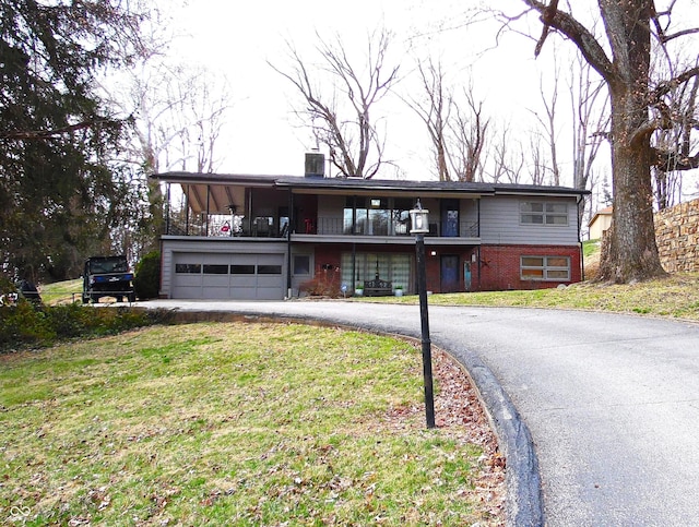 view of front of home with an attached garage, a front yard, central AC unit, a balcony, and driveway