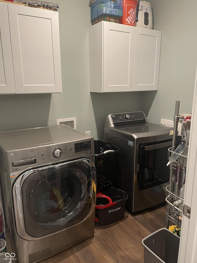 laundry room featuring cabinet space, washing machine and dryer, and wood finished floors