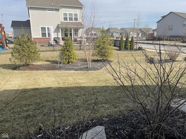 view of yard with a playground, fence, and a residential view