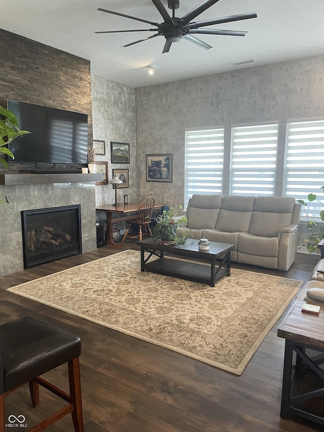 living room with visible vents, plenty of natural light, wood finished floors, and a ceiling fan