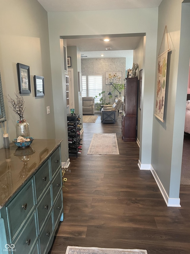 hallway with baseboards and dark wood-style flooring