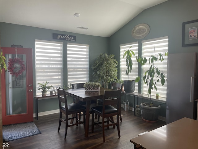 dining area with visible vents, dark wood-type flooring, baseboards, and vaulted ceiling