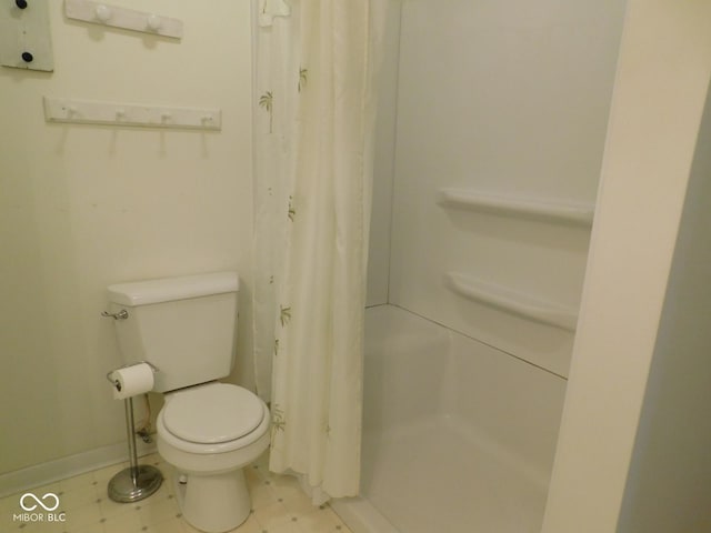 full bath featuring toilet, a shower with shower curtain, and baseboards