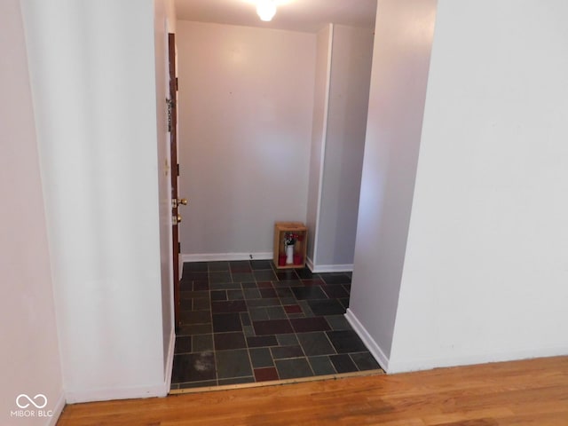 hallway featuring wood finished floors and baseboards