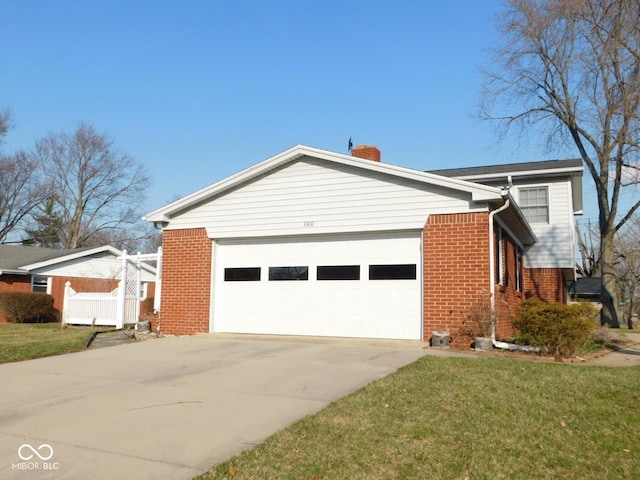 view of home's exterior featuring brick siding, concrete driveway, a lawn, a chimney, and a garage