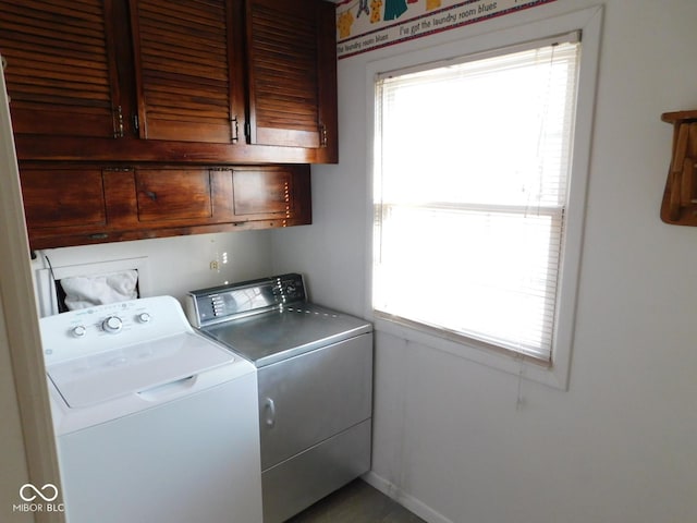 washroom featuring cabinet space, washing machine and dryer, and baseboards