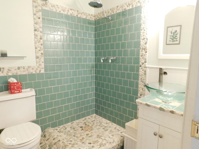 full bath with toilet, tile walls, wainscoting, and a tile shower