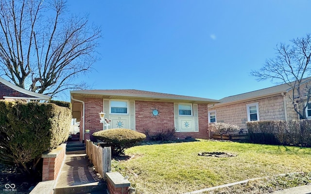 single story home with a front yard, fence, and brick siding