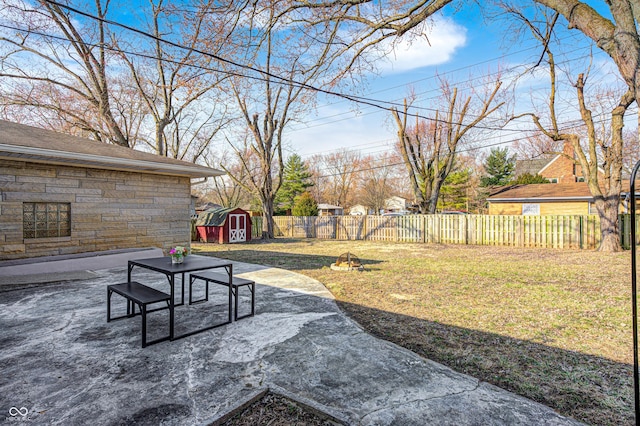 view of yard featuring a storage shed, a patio, fence private yard, and an outdoor structure