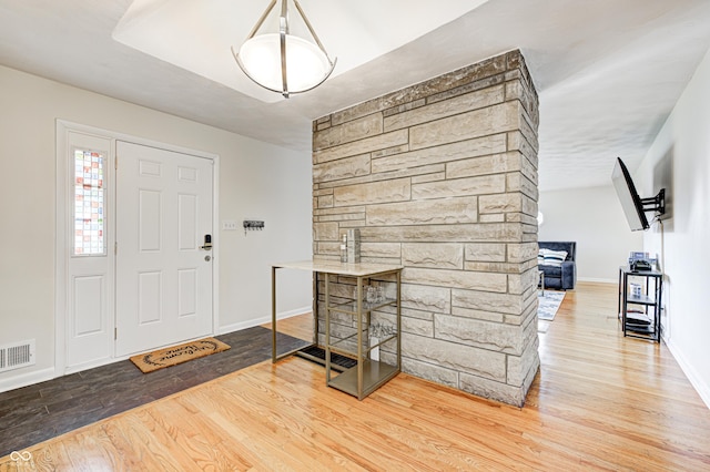 entrance foyer featuring visible vents, baseboards, and wood finished floors