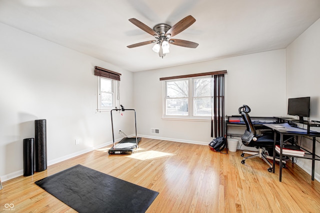 office featuring ceiling fan, visible vents, baseboards, and wood finished floors